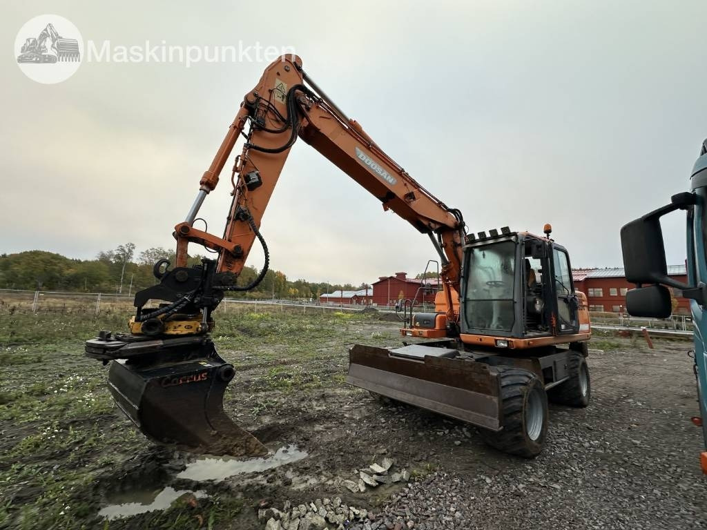 Doosan DX 140 W med vagn och redskap - Kolesové rýpadlo: obrázok 1 Doosan DX 140 W med vagn och redskap - Kolesové rýpadlo: obrázok 1